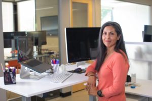 Frau an höhenverstellbarem Schreibtisch
