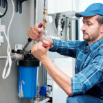 Ein Handwerker installiert einen Hauswasserfilter