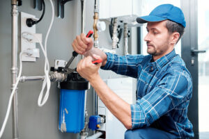 Ein Handwerker installiert einen Hauswasserfilter