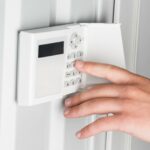 Eine Person bedient die Basisstation einer Alarmanlage