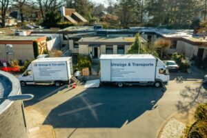 Zwei Umzugsfahrzeuge vor einem Wohnhaus – professionelle Umzugsabwicklung