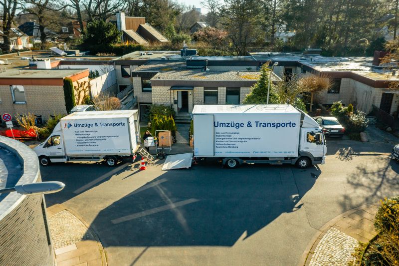 Zwei Umzugsfahrzeuge vor einem Wohnhaus – professionelle Umzugsabwicklung