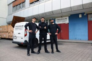 Drei Mitarbeiter vor dem Einsatzfahrzeug eines Entrümpelungsunternehmens
