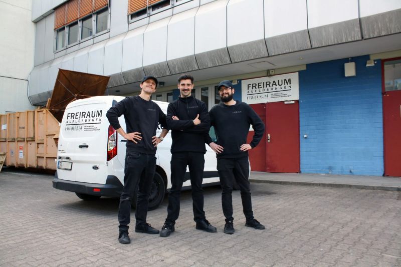 Drei Mitarbeiter vor dem Einsatzfahrzeug eines Entrümpelungsunternehmens