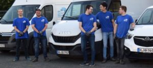 Team eines Haushaltsauflösungsunternehmens vor Transportern